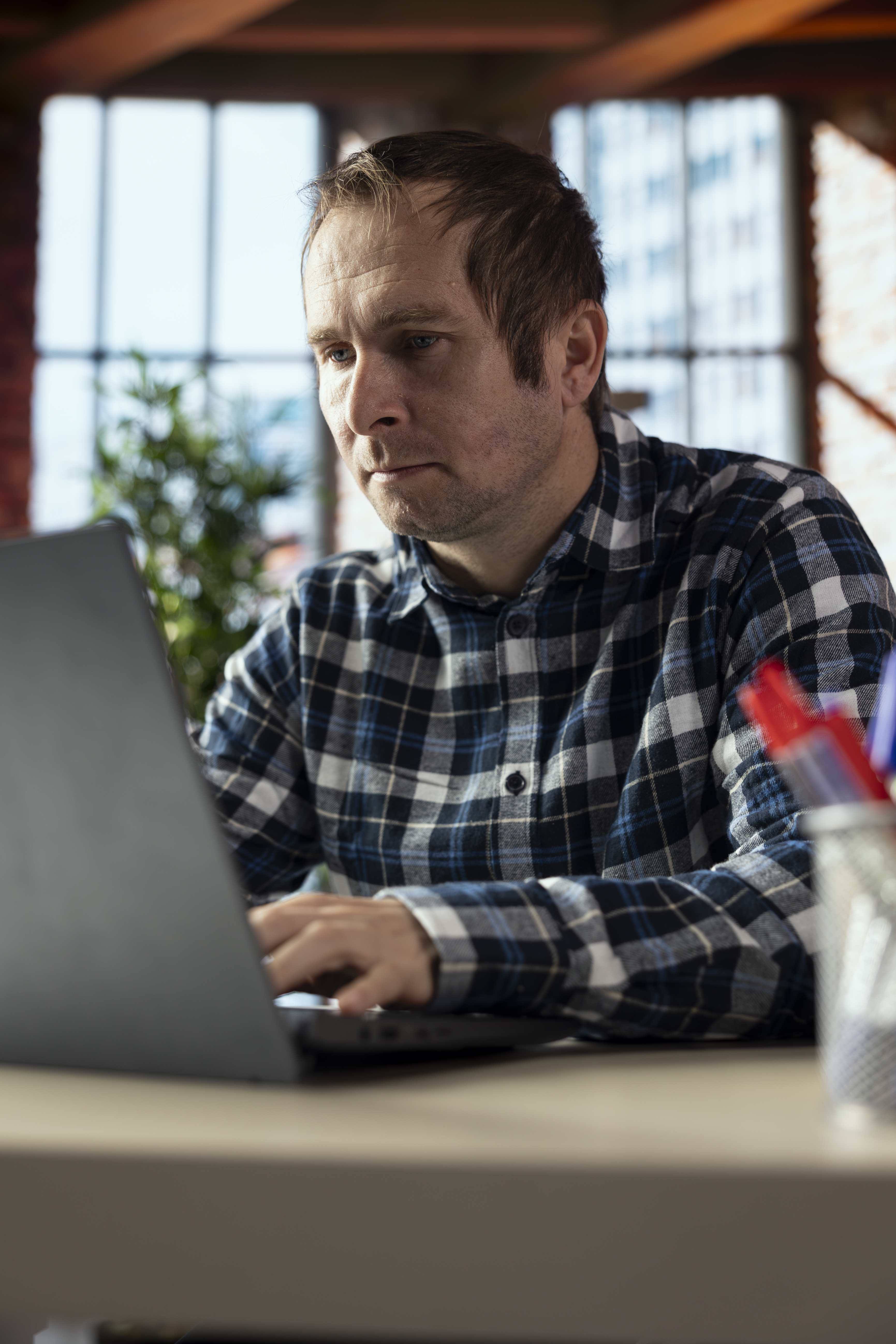 man-home-office-desk-editing-documents-laptop-updating-reports-files.jpg