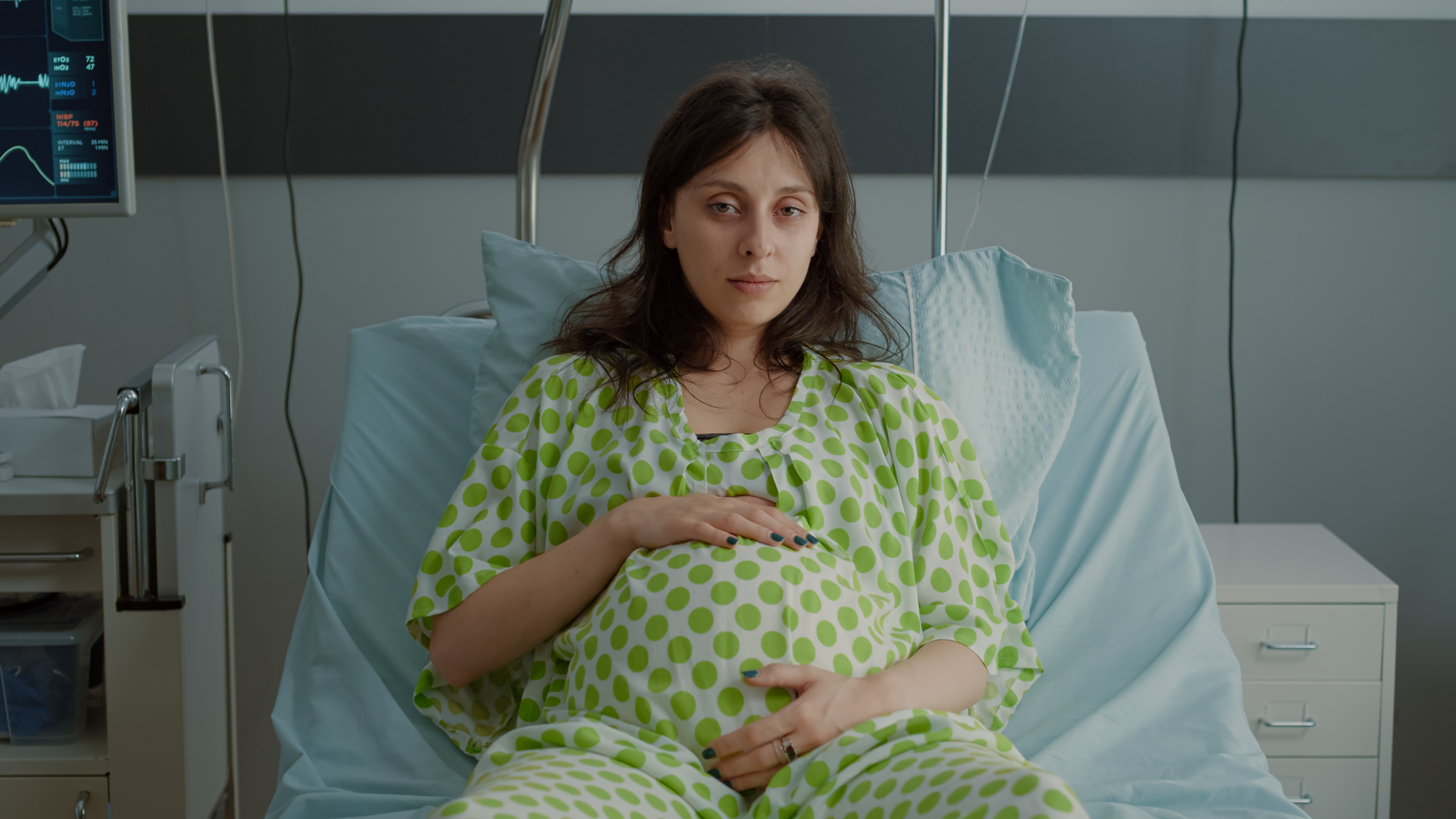 portrait-pregnant-woman-laying-hospital-ward-bed-with-medical-equipment-preparing-childbirth-maternity-caucasian-patient-holding-hand-belly-while-sitting-expecting-baby.jpg