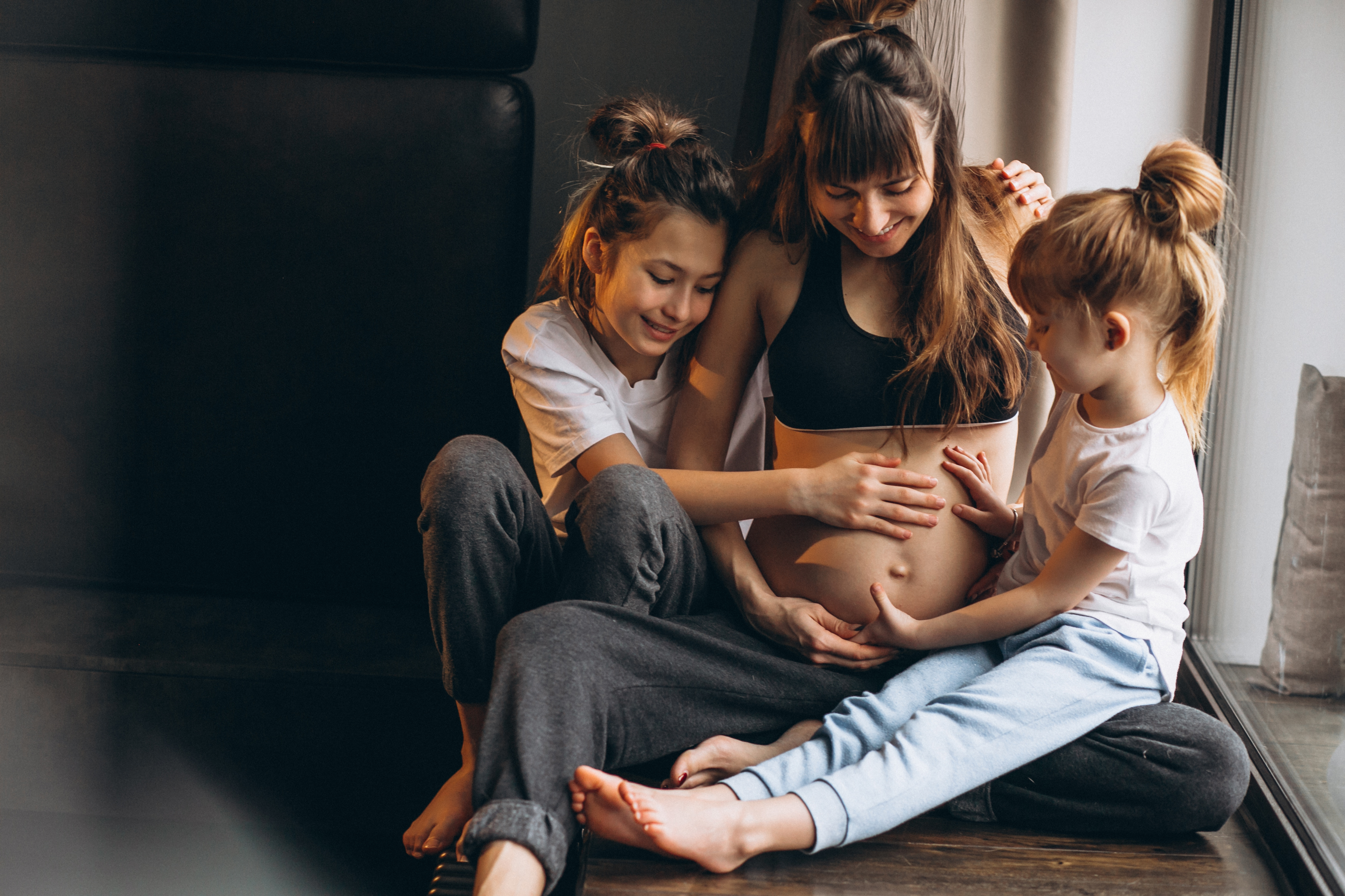 pregnant-woman-with-children-sitting-by-window.jpg