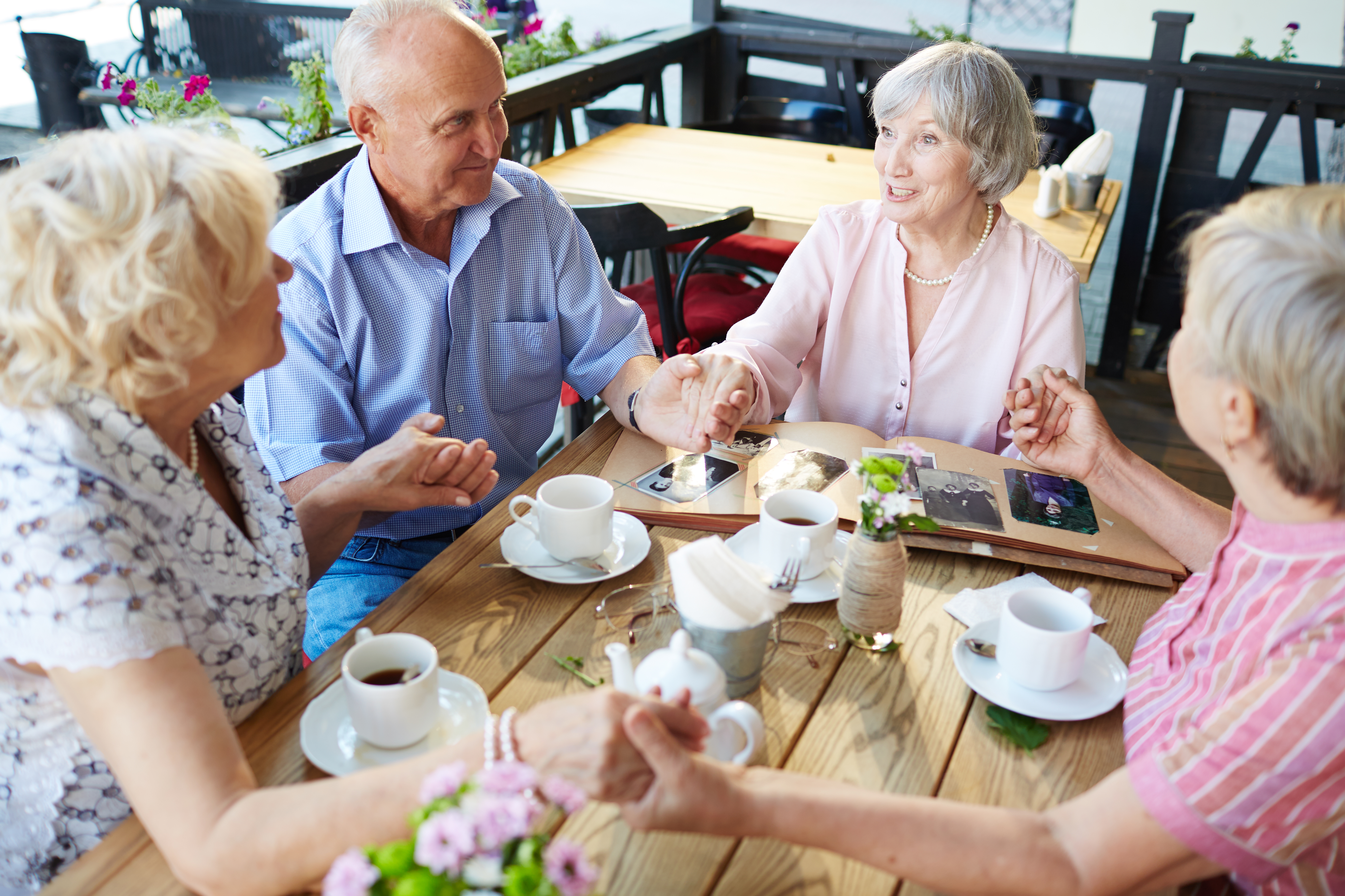 seniors-holding-hands-cafe.jpg