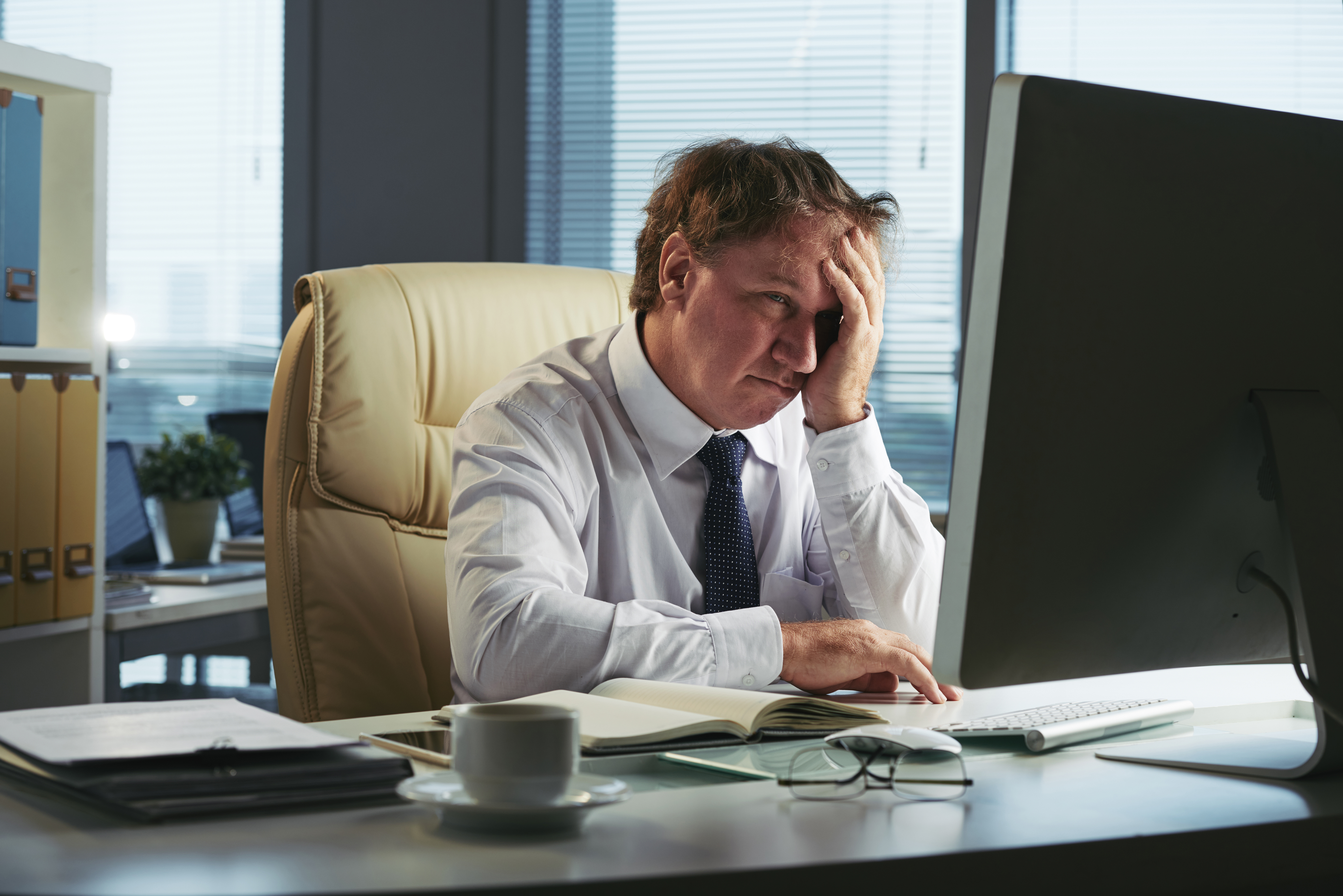 stressed-man-with-headache-working-early-morning-his-office.jpg