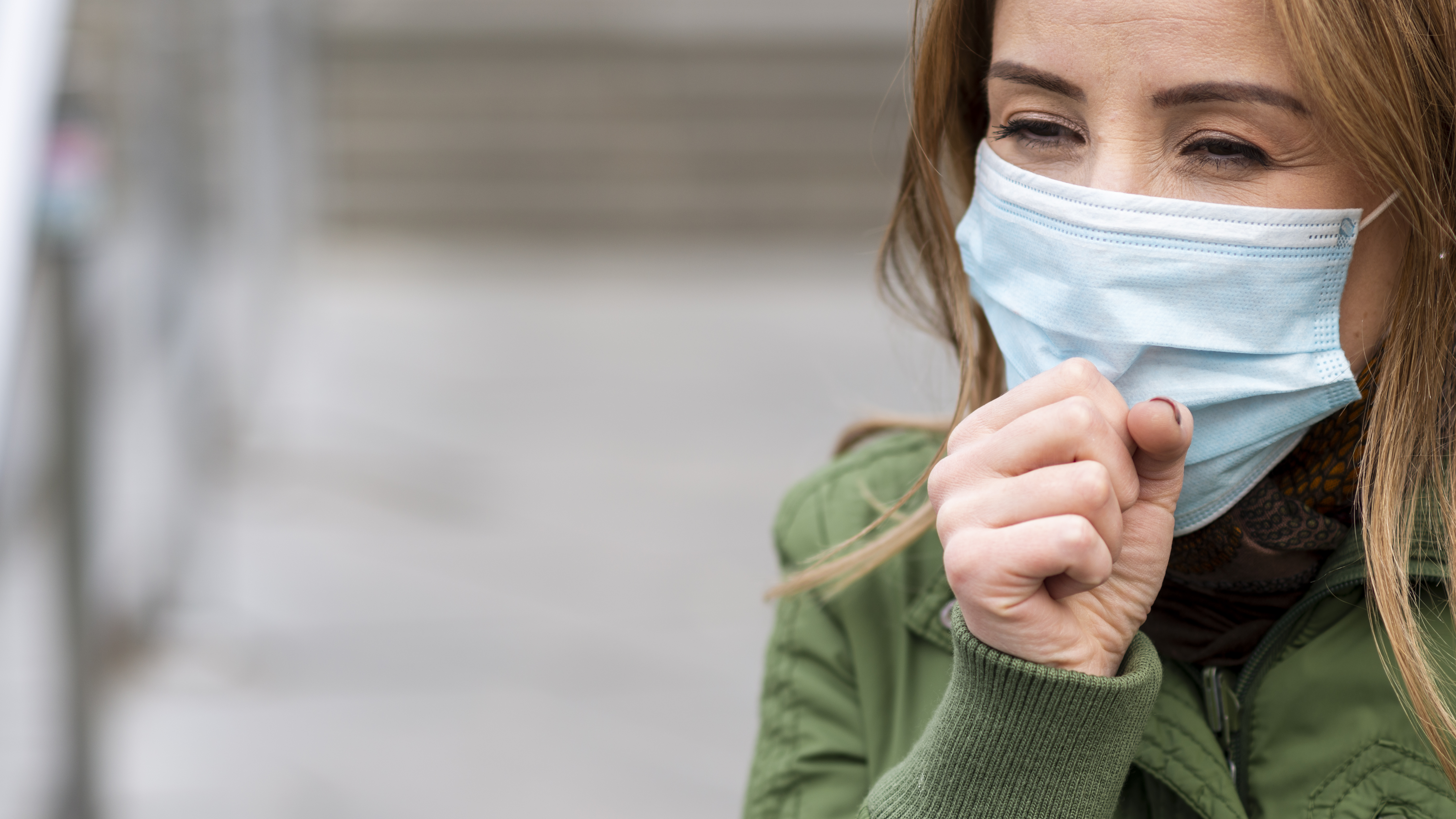 woman-coughing-public-space-wearing-mask.jpg