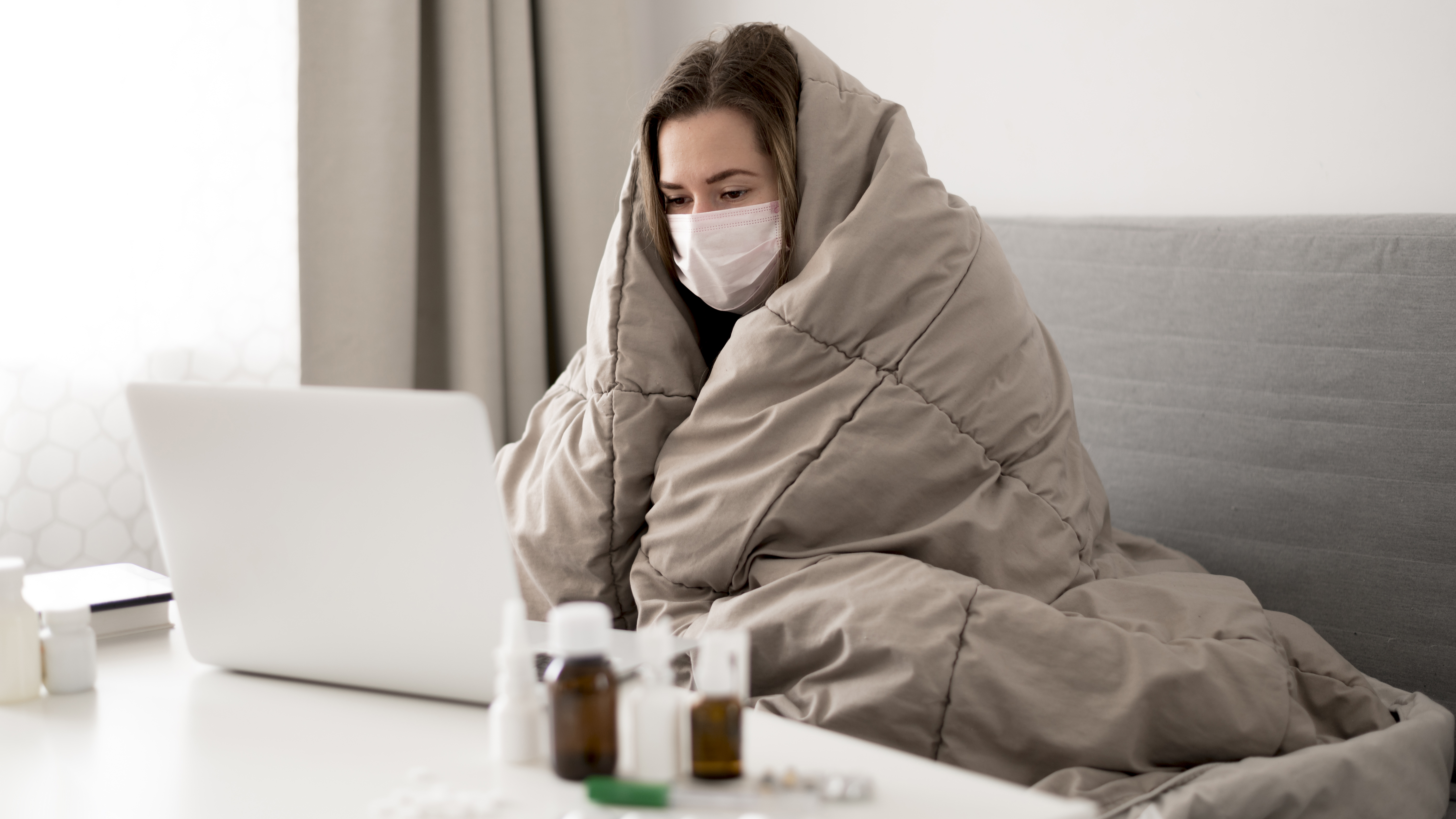 woman-wearing-medical-mask-wrapped-blanket.jpg