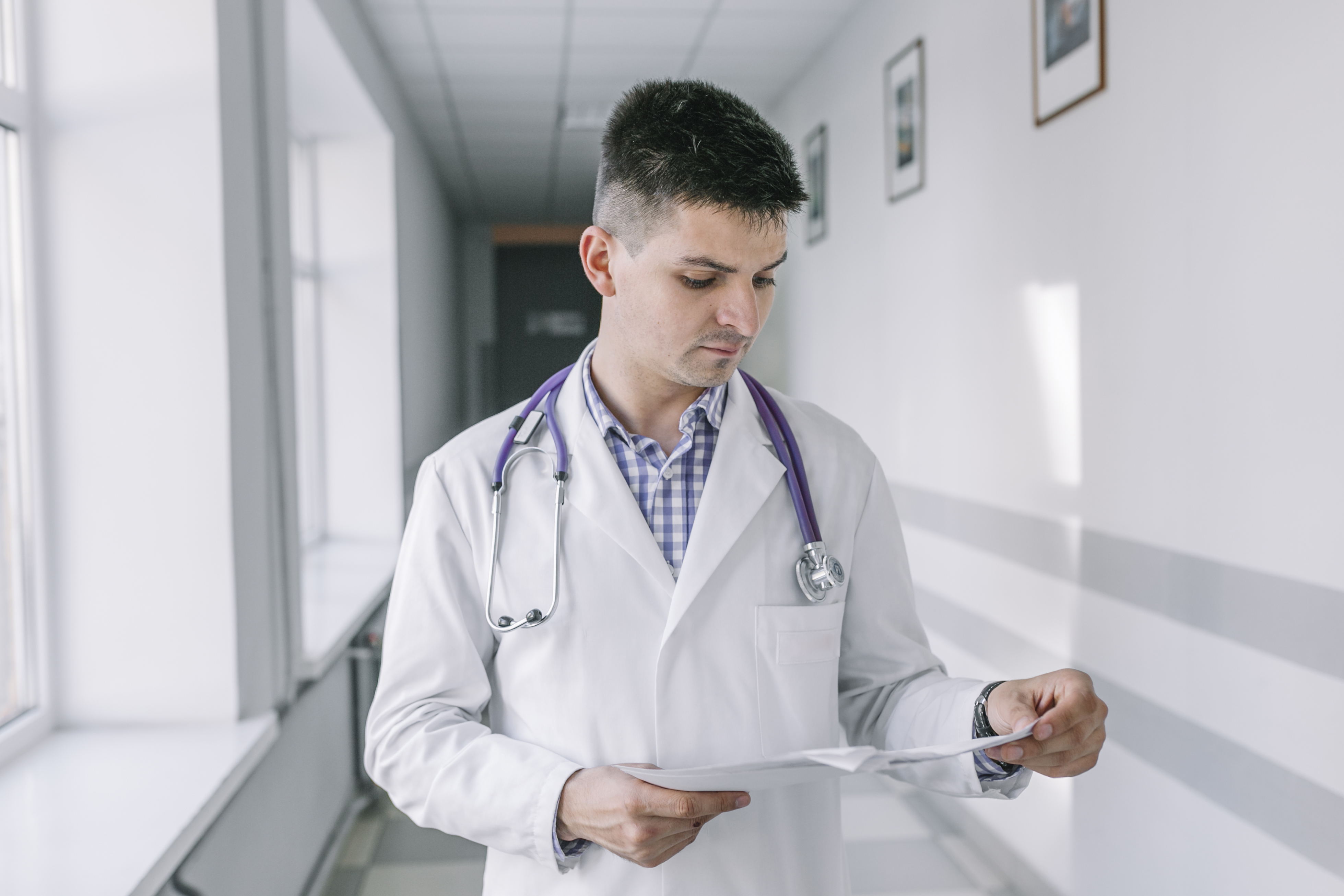 young-doctor-with-papers-standing-clinic.jpg