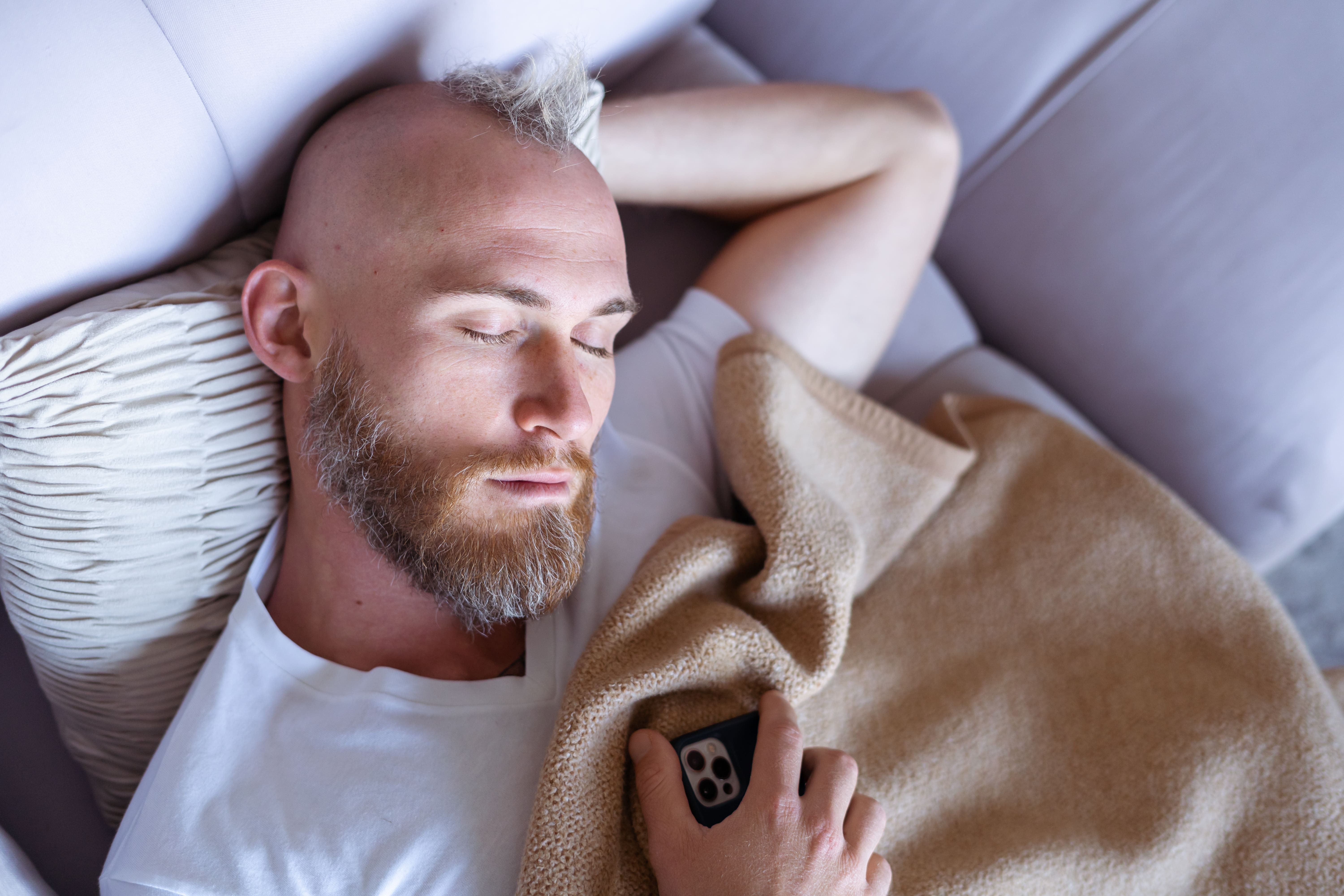 young-man-home-fell-asleep-couch-with-mobile-phone-2.jpg